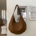 Grande borsa hobo marrone con stampa leopardata in pelle opaca appesa a una parete bianca - Marrone