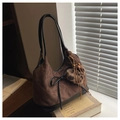 Close-up of brown quilted suede hobo bag with leopard print pompom and leather fringe - With Charm / Brown