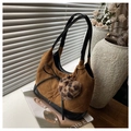 Brown suede tote bag with diamond stitching, black bow, and leopard heart charm on a ledge - With Charm / Brown