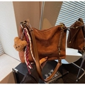 Detail der braunen Wildleder-Tragetasche mit Bärenanhänger und modischer Prägung - Mit Anhänger / Braun mit Anhänger