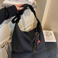 Quilted black tote bag with adjustable strap and decorative charm for daily commuting - Black