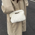 White cable knit quilted makeup bag with gold chain strap shown on beige trench coat - White