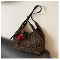 Dettaglio della borsa tote leopardata con ciondoli a pompon rossi e marroni - Marrone con ciondolo