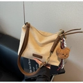 Detailansicht der khakifarbenen Wildledertasche mit braunem Logo und Bärenanhänger - Mit Anhänger / Beige Mit Anhänger