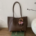 Detail of dark brown pebble leather tote bag with long straps and plush bear charm - Tan With Charm