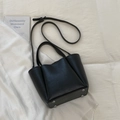 Detail view of black pebble leather bucket bag with silver bottom studs and handles - No Pendant / Black