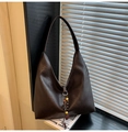 Detalle de bolso hobo vintage marrón con adorno de cuentas de madera sobre una revista - Marrón