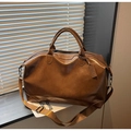 Detalle de un gran bolso tote de cuero sintético marrón con etiqueta y correa de hombro - Marrón