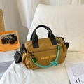 Bolso bandolera de nailon marrón con asas negras y accesorio de cordón verde - Marrón con colgante