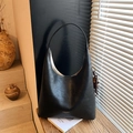 Borsa hobo minimalista in pelle nera con scritte dorate in una calda scena soleggiata - Nero con ciondolo