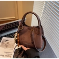 Close-up of brown suede bucket bag with leather handles and bohemian beaded pendant - Coffee with Pendant