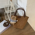 Detail of brown suede tote bag with leather handle, strap, and plush bear charm - Brown with Pendant