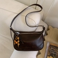 Sac bandoulière demi-lune marron foncé avec perles bohèmes sur un canapé, style élégant - Avec Pendentif / Marron