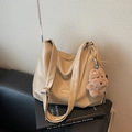 Beigefarbene Schultertasche mit Raffung und braunem Bärenanhänger auf Büchern - Khaki (Mit Anhänger)