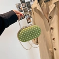 Grass green polka dot crossbody bag with gold round handle and bow clasp detail - Green