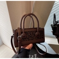 Gros plan détaillé du sac en cuir marron avec panneau léopard et détails de boutons - café
