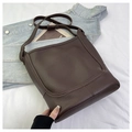 Vue détaillée du sac seau marron foncé en cuir grainé sur une veste en jean - Grand / Café Grand