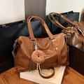 Brown soft leather tote bag for women with woven strap and plush charm on white magazine box - Brown with Pendant