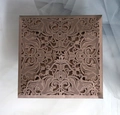 Détail de l'invitation de mariage carrée ajourée au laser avec motifs floraux élégants - café