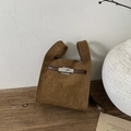 Detail shot of brown suede bucket bag featuring polished metal twist lock and leather straps - Brown