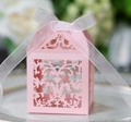 Pink laser-cut lace wedding candy box with white ribbon on a white plate - Pink