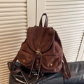 Vintage brown suede backpack with drawstring closure and golden buckles on book - Coffee