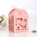 Close-up of pink laser-cut flower gift box with elegant satin ribbon bow and macro detail - Pink