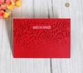 Detail of red laser-cut wedding invitation featuring rose patterns and WEDDING text - Red