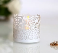 Macro view of white spider web laser-cut candle cover with warm LED light glow - White