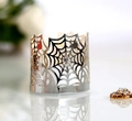 Macro detail of laser-cut spider web metal tea light holder with polished silver finish - Reflective Silver
