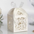 Detail of white laser-cut wedding favor box with floral patterns and a ribbon tie - Ivory