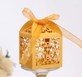 Macro shot of yellow laser-cut gift box with intricate floral patterns and orange ribbon - Gold