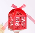 Close-up of red laser-cut wedding favor box with floral patterns and a ribbon bow - Pearlescent Red