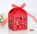 Close-up of laser-cut floral hollow patterns on red candy gift box with silk ribbon - Pearlescent Red