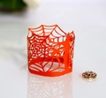 Macro detail of laser-cut orange spider web paper wrapper for Halloween LED tea light - Orange Red
