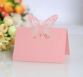 Pink laser-cut butterfly place cards for weddings and parties on a floral background - Pink