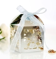 Macro detail of laser-cut silver favor box with blue silk ribbon and rhinestone pendant - Reflective Silver