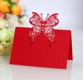 Detail showing intricate laser-cut butterfly pattern on red paper wedding table card - Pearlescent Red