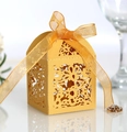 Detail showing gold laser-cut floral patterns and orange organza ribbon on candy box - Gold
