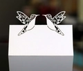Vue macro des marque-places colibri découpés au laser avec motif de vigne ajouré élégant - Blanc