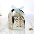 Detail of silver laser-cut wedding favor box with intricate floral pattern and satin ribbon - Reflective Silver