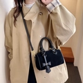 Chic black mini Boston bag with suede finish and cute bow detail on a stylish model - Black