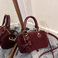 Mini burgundy suede Boston bag with leather bow charm and gold hardware on denim - Red
