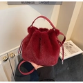 Detailed view of red plush bucket bag with leather handle and drawstring closure - Red