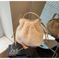 Close-up of fluffy faux fur bucket bag with drawstring closure and leather handle - Khaki