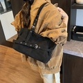 Detail of black suede tote bag featuring silver eyelets and adjustable strap buckle - Black