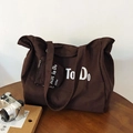 Brown canvas tote bag with To Do print and small matching zippered pouch on wooden desk - Brown