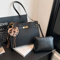 Set borsa tote in pelle nera con ciondolo a cuore e pochette coordinata in ambiente ufficio - Nero con ciondolo