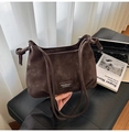 Detalle de bolso bandolera de ante marrón oscuro con correa de nudo y parche de cuero - Marrón