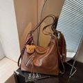 Mochila retro de cuero marrón con colgante de oso y flecos, mostrada con estilo - Con Colgante de Peluche / Marrón
